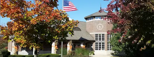 Round Lake Village Hall surrounded by autumn trees in Round Lake, Illinois.