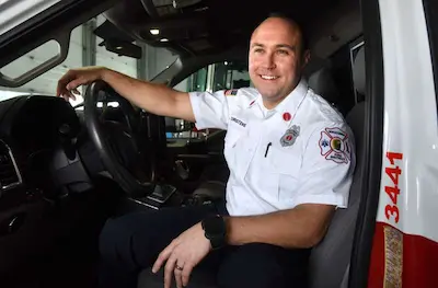 Community paramedic seated inside an emergency response vehicle.