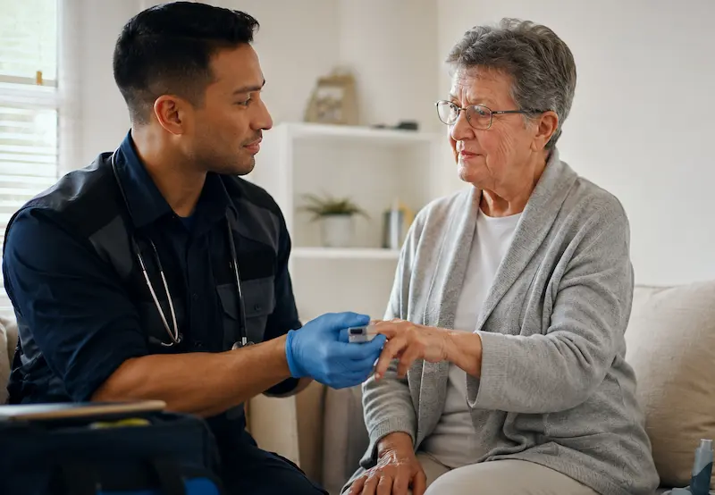 Healthcare professional providing in-home wellness support for an older adult patient.